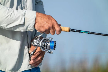 Fisherman holding rod and reeling in