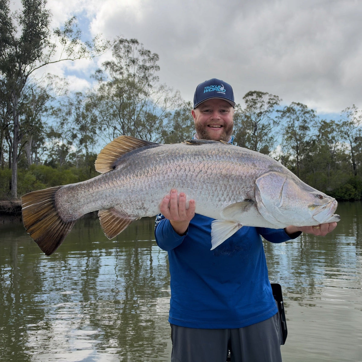 Angler holding a large barramundi caught on a prawn soft plastic at Baffle Creek, Queensland