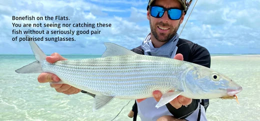 Angler wearing Spotters sunglasses while holding a fish, showcasing ultimate UV protection and style for outdoor adventures